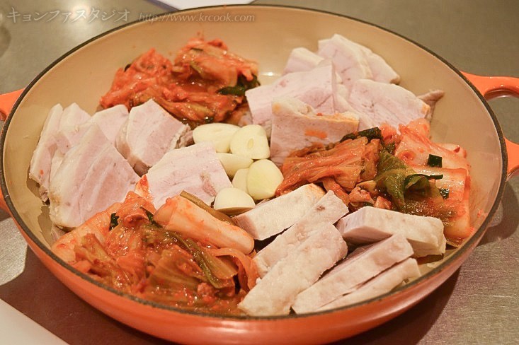 やわらかく茹でた豚肉に熟成キムチと漬けたてキムチの二種類を合わせて盛り込みます。にんにくも。