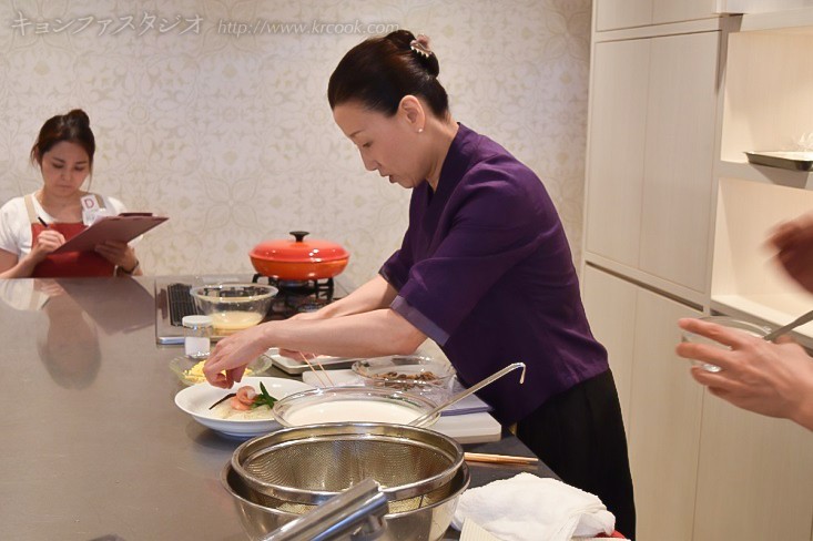 あわただしくて出来上がりの料理写真がありません（笑）。 極上のネaンコンクッス（豆乳そうめん）を盛り付ける先生。