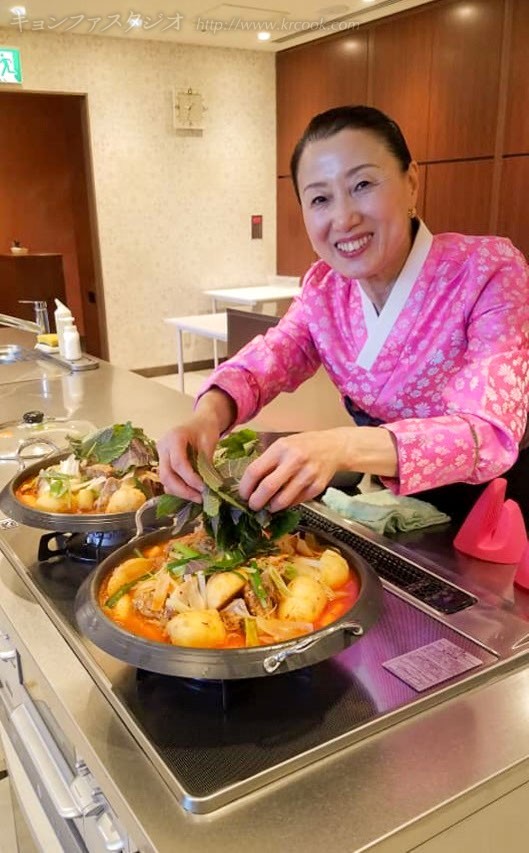 えごまの葉・えごまの粉をかける先生