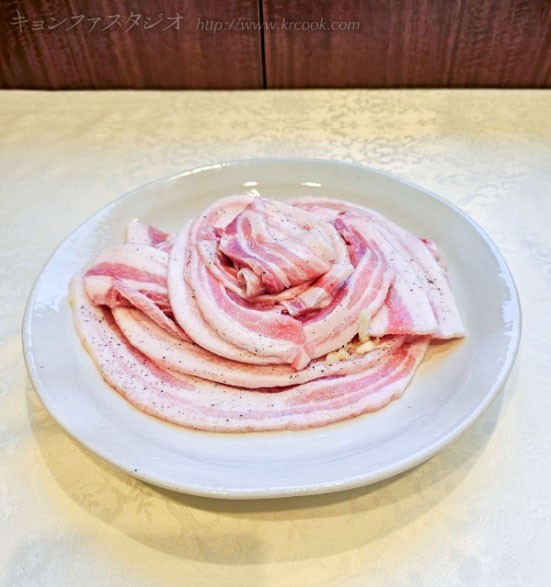 下味のついた豚バラ肉を盛りつけます。