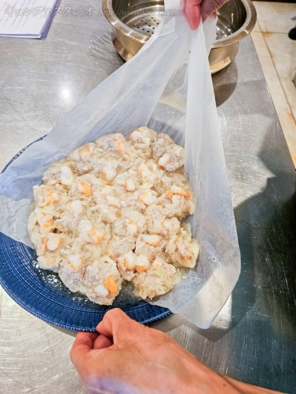 クキングシートごとお皿にスライドさせ、肉汁をこぼさないようにします。