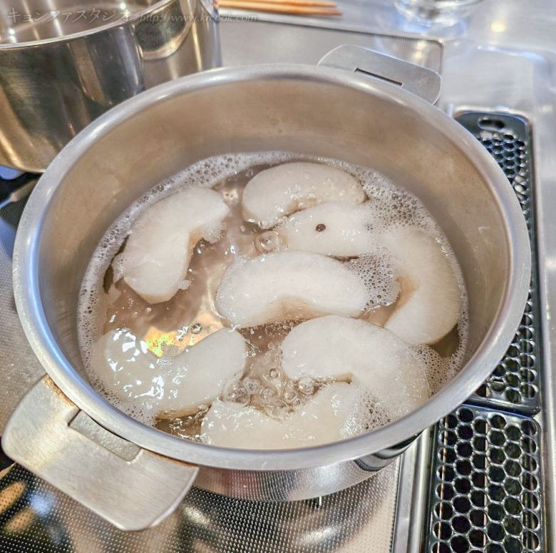 粒こしょうを刺した梨を生姜入りの汁で煮て、そのまま冷まします。