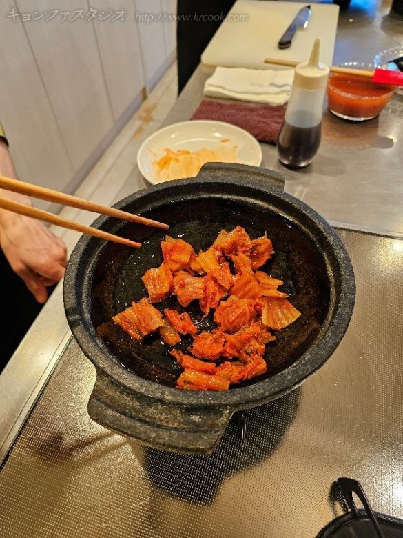 キㇺチを炒めてさんまをのせます。キㇺチを先に炒めて 